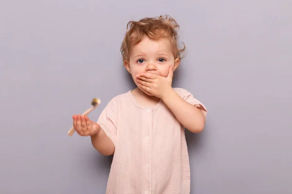Здивована Маленька Дівчинка Тримає Зубну Щітку Ізольовано Сірому Фоні Навчаючись — стокове фото