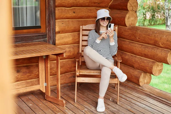 Positive Woman Wearing Striped Shirt Panama Sunglasses Sitting Terrace Wooden — Stock Photo, Image
