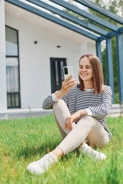 Cheerful Woman Wearing Striped Shirt Leggins Sitting Grass Modern House — Stock Photo, Image