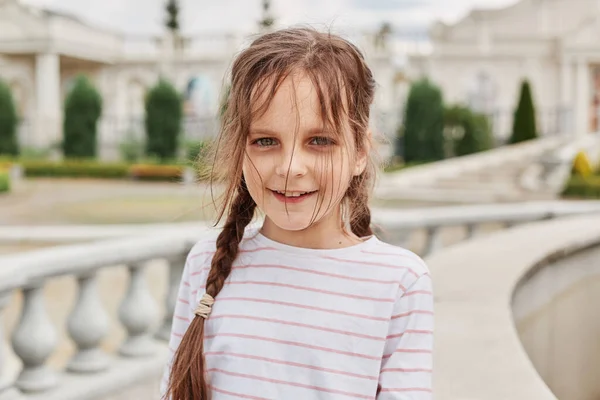 Senyum Gadis Kecil Mengenakan Bergaris Garis Kemeja Berpose Kota Dengan — Stok Foto