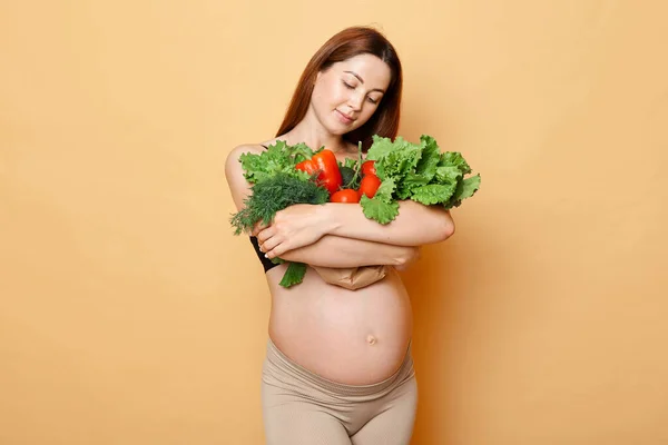 Charming Brown Haired Pregnant Woman Embraces Fresh Vegetables Posing Isolated — Stock Photo, Image