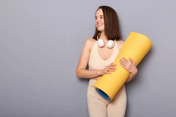 Glimlachende Vrouw Met Yogamat Voor Meditatie Die Wegkijkt Naar Grijze — Stockfoto