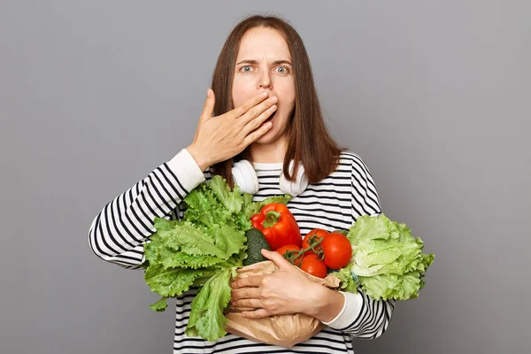 Chockad Kvinna Som Håller Grönsaker Täcker Munnen Med Handen Isolerad — Stockfoto