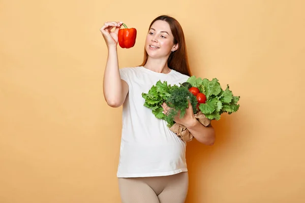 Glad Gravid Kvinna Håller Färska Grönsaker Poserar Isolerade Över Beige — Stockfoto
