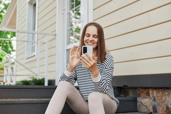 Adorable Smiling Woman Wearing Striped Shirt Using Phone Sitting Porch — Stock Photo, Image