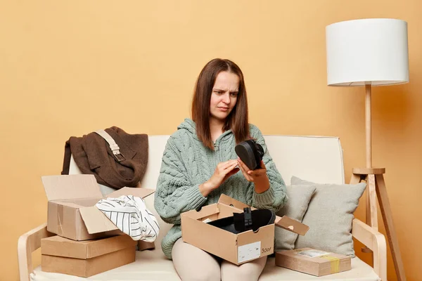 Upset Woman Sitting Sofa Boxes Clothing Beige Wall Unpacking Parcel — Stock Photo, Image