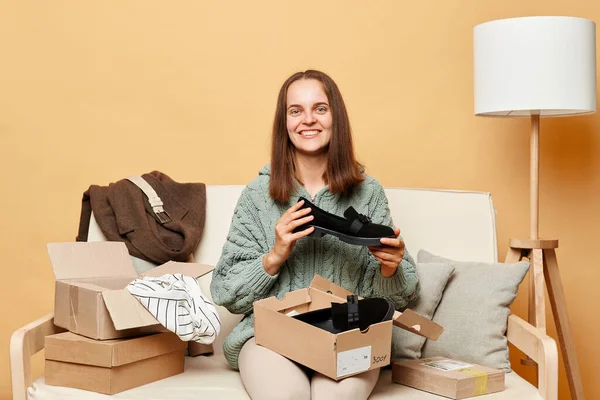Smiling Satisfied Woman Sitting Sofa Boxes Clothing Beige Wall Buying — Stock Photo, Image