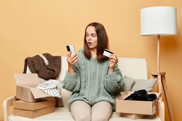 Surprised Astonished Woman Sitting Sofa Boxes Clothing Beige Wall Buying — Stock Photo, Image