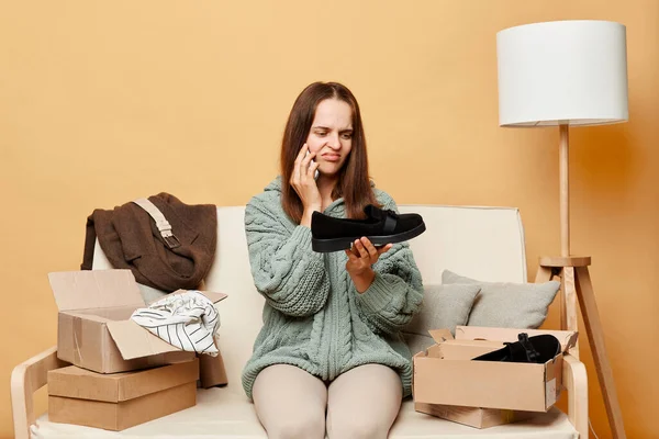 Sad Disappointed Woman Sitting Sofa Boxes Clothing Beige Wall Talking — Stock Photo, Image