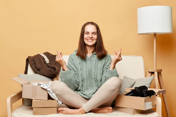 笑顔魅力的な女性のお店の顧客に座ってソファアンパック小包配達箱に対してベージュ壁ポージングとともにムドラジェスチャー練習ヨガ — ストック写真