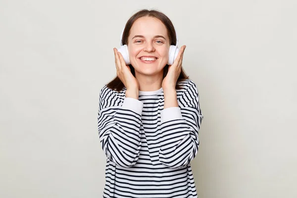 Uśmiechnięta Młoda Radosna Kobieta Pasiastej Koszuli Słuchająca Muzyki Słuchawkach Odizolowana — Zdjęcie stockowe