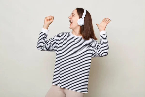 Atrakcyjna Pozytywna Młoda Kobieta Pasiastej Koszuli Słuchająca Muzyki Słuchawkach Odizolowanych — Zdjęcie stockowe
