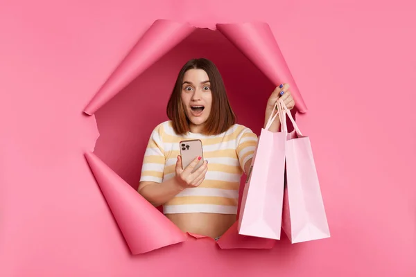 Geschokte Vrouw Draagt Gestreept Shirt Breken Door Roze Papieren Gat — Stockfoto