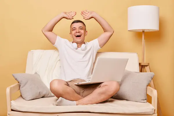 ソファの閲覧 デジタルレジャー インターネット接続 幸せな陽気な若い男仕事上のラップトップコンピュータ座っています上の快適なソファに自宅で笑います祝う成功 — ストック写真