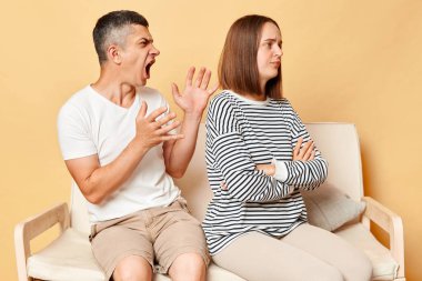 Gücenmiş kız erkek arkadaşını görmezden geliyor, geri dönüyor, yanlış anlama, çatışma, öfke ve öfkeyle bağıran sinirli saldırgan adam, aile içi çatışma..