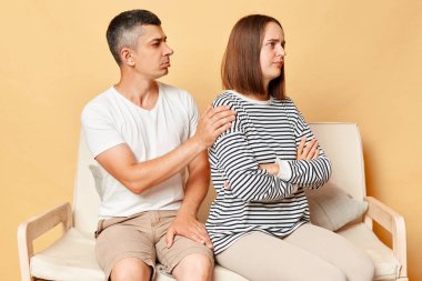 Aile ilişkileri sorunları. Esmer bir adam aile kavgası sonrası nazikçe kadınlara dokunuyor, genç bir koca üzgün bir eşten çatışma üstüne af diliyor. Samimi erkek arkadaşım tartıştığımız için üzgün..