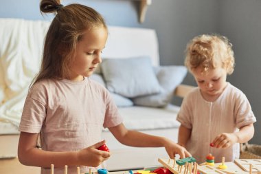 Renkli çocuk odası eğlencesi. Eğitimli bebek oyuncakları. Yaratıcı oyun odası aktiviteleri. Mutlu çocukluk anıları. Evde eğitici oyuncaklarla oynayan küçük kızlar..