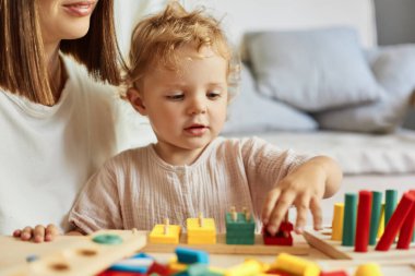 Bilişsel gelişim aktiviteleri. Ebeveyn-çocuk yakınlaşma deneyimleri. Montessori öğrenme araçları. Anaokulunun merak uyandırıcı soruları. Öğretmen ya da anne evde mantık oyuncaklarıyla oynuyor..