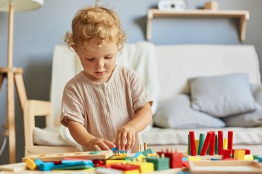 Renkli öğrenme oyuncakları. Bina blokları eğlenceli. Oyuncak çocuk yuvası aktiviteleri. Çocukluk geliştirme oyunları. Küçük sarışın kız. Evinde ahşap oyuncaklarla oynaşıyor..