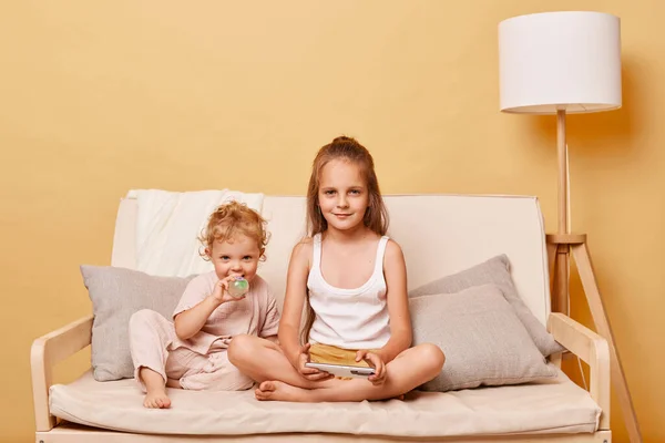 Relaxed Charming Little Girls Sisters Using Phone While Sitting Sofa — Stock Photo, Image
