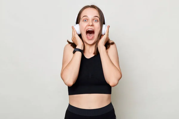 Glücklich Aufgeregte Schlanke Frau Mit Kopfhörern Sportkleidung Posiert Vor Grauem — Stockfoto