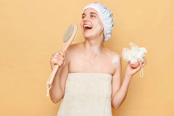 Szczęśliwa Zabawna Kobieta Nosi Czepek Prysznicowy Stojąc Odizolowany Nad Beżowym — Zdjęcie stockowe