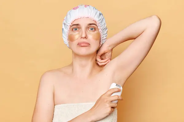 Nieszczęśliwa Kobieta Czepku Prysznicowym Stojąca Beżowym Tle Pozująca Łatami Pod — Zdjęcie stockowe