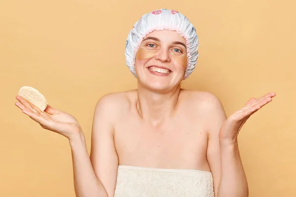 Piękna Kobieta Czepku Prysznicowym Stojąca Beżowym Tle Wzruszająca Ramionami Pozująca — Zdjęcie stockowe