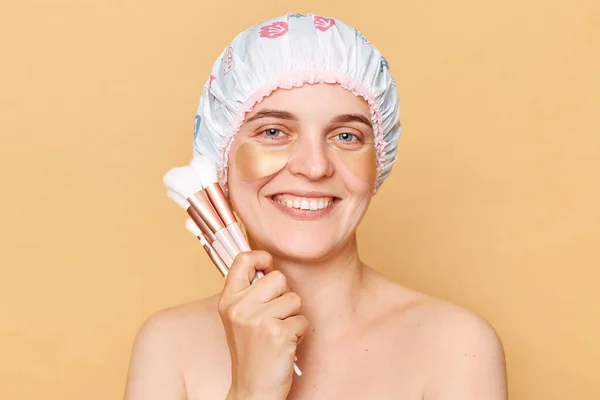 Uśmiechnięta Kobieta Nosząca Czepek Prysznicowy Stojąca Beżowym Tle Patrząc Kamerę — Zdjęcie stockowe