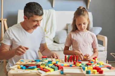 Küçük bir çocuk yuvası keşfi. Oyun alanı eğlencesi ve oyunları. Bebeklerin eğitici oyuncakları. Anaokulunun neşeli aktiviteleri. Babası evde kızıyla eğitim oyuncakları oynuyor.