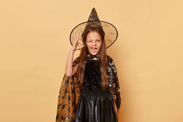 Волнующая Маленькая Девочка Костюме Ведьмы Шляпе Карнавального Конуса Бежевом Фоне — стоковое фото