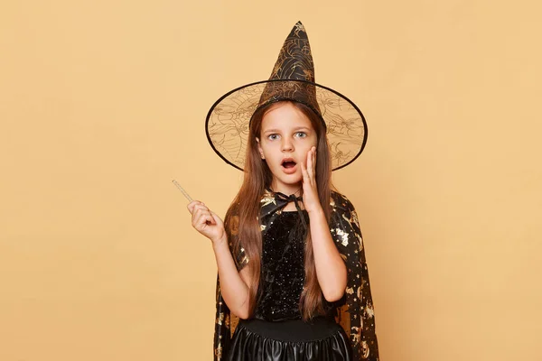 Шокированная Маленькая Девочка Костюме Ведьмы Шляпе Карнавального Конуса Изолированная Бежевом — стоковое фото