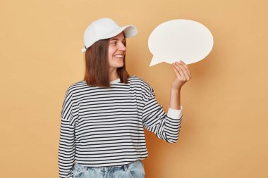 Fikirlerle dolu bir zihin hayal etmek. Bir eylem planı üzerinde karar veriyorum. Boş bir kart tuval sunuyor. Çizgili gömlek ve beysbol şapkası takan neşeli bir kadın boş beyaz konuşma balonu tutuyor.