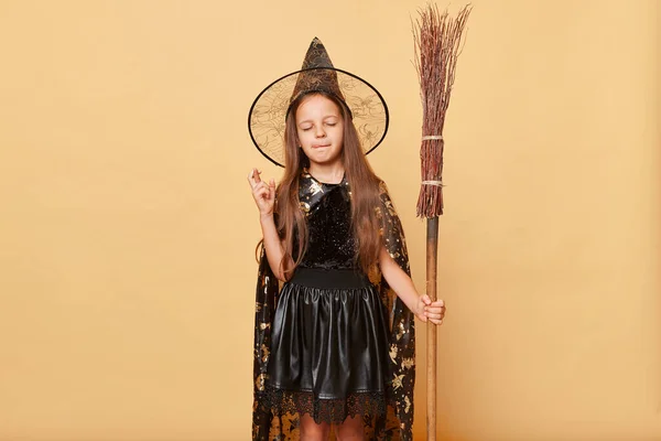 Hoopvol Meisje Gekleed Heks Kostuum Houden Bezem Geïsoleerd Beige Achtergrond — Stockfoto