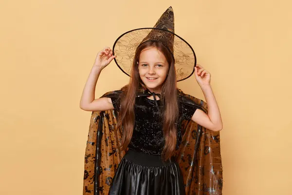 Радостная Смешная Улыбающаяся Девочка Костюме Хэллоуина Шляпе Ведьмы Бежевом Фоне — стоковое фото