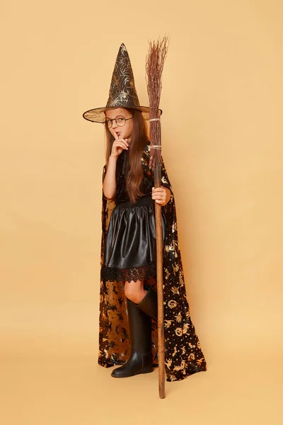 Halloween Varázslat Gyerekkori Varázslat Titokzatos Kislány Fekete Köpenyben Seprűvel Bézs — Stock Fotó