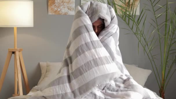 秋のうつ病について 睡眠不足の朝に仕事に行きたくない 十分な睡眠を持たない ブランケットで包まれた自宅でベッドに座っている眠っている若い女性 — ストック動画