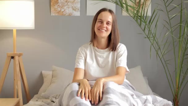 Fiatal Boldog Visel Fehér Póló Mosolyog Miközben Ágyon Alvás Után — Stock videók