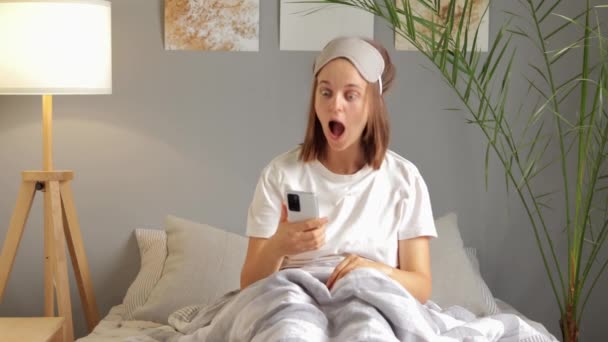 Beyaz Tişört Uyku Maskesi Takan Komik Bir Kadın Elinde Akıllı — Stok video