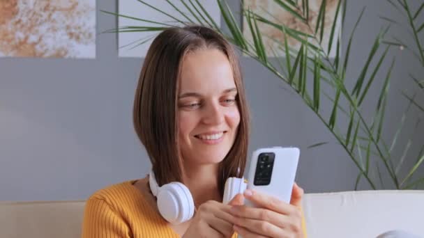 Boldog Szép Visel Sárga Ing Otthon Segítségével Smartphone Görgetés Online — Stock videók