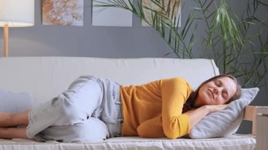 Sarı gömlekli, kot pantolonlu, gülümseyen güzel kız yumuşak koltukta dinleniyor. Hayal kuruyor, hafta sonu uykusuna yatıyor, evde keyfine bakıyor, dinleniyor..