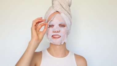 Günlük bakım rutini. Cilt nemlendirici maske ve kolajen hiyalüronik asit ile cilt nemlendirici yüz maskeleri kullanan mutlu genç kadın..