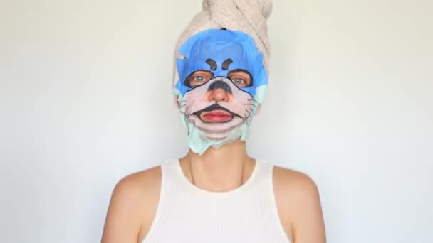 女性スキンケアのルーチン 化粧マスクアプリケーション 健康とスキンケア療法 若返りのためのスパトリートメント 動物のマスクでシャワーを浴びた後 頭にタオルが付いている陽気な少女 — ストック動画
