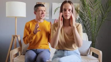 Aile kavgası. Çiftin sorunları. Boşanma kararı. Üzgün kız arkadaş. Bunalımlı erkek arkadaş. İlişki psikolojisi. Oturma odasındaki kanepede oturan kızgın aile kocası beşinde bağırıyor..