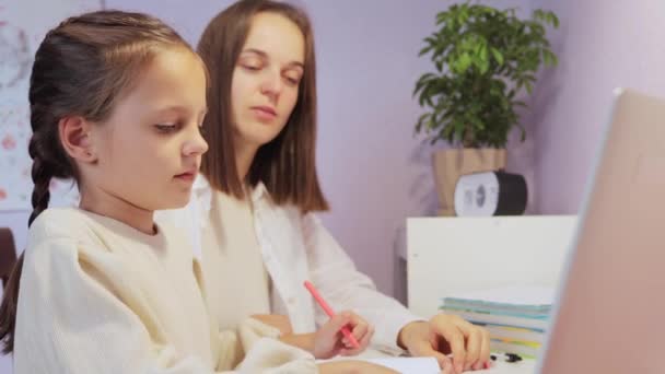 专心致志的小女孩 带着辫子坐在笔记本电脑前 与她的老师一起 试图在远程教育中理解新的课题 — 图库视频影像