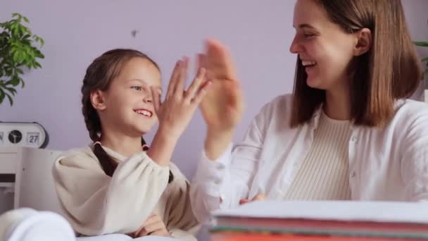 Jovencita Alegre Con Coletas Terminando Trabajo Escolar Con Ayuda Madre — Vídeo de stock