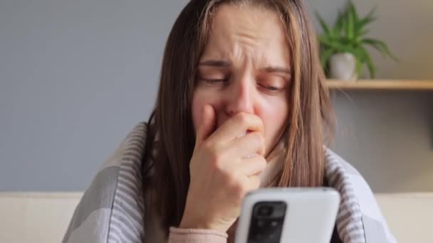 白种人心烦意乱忧心忡忡的女人在室内用智能手机与医生咨询带有流感症状的手机表达哀伤 — 图库视频影像