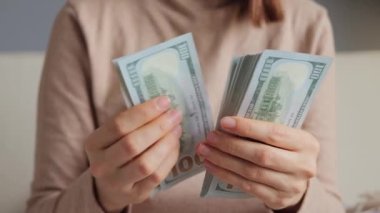 İş kadınlarının elinde Amerikan parası var. Kadın kasiyer, Amerikan dolarlarını sayıyor. Kadın, elinde dolar banknotlarıyla eğleniyor..