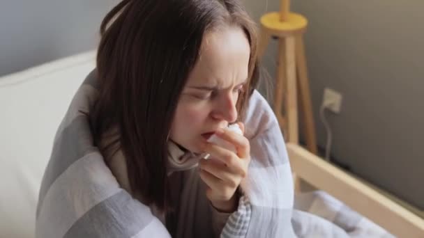 自宅に座っている不気味な女性は インフルエンザを患っている間に隔離中に家に滞在する高温を持っています — ストック動画