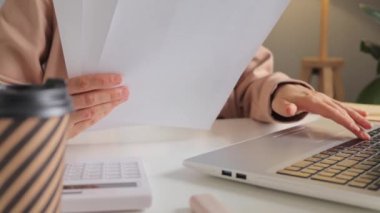 İş yerinde elinde kağıt hesap belgeleri tutan tanınmayacak kadar başarılı bir iş kadını. Bilgisayarlı, açık modern ofis bilgisayarlı..